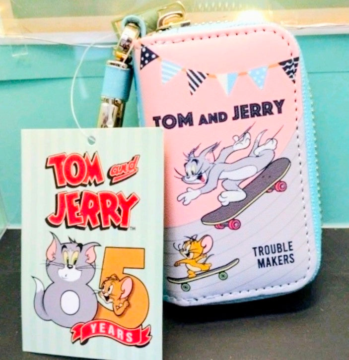 Pink Tom and Jerry smart key case with skateboard illustration and Trouble Makers text