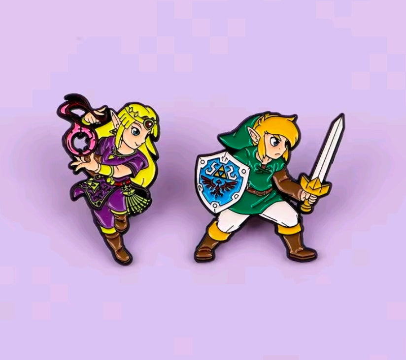 Two enamel pins: Link in green with sword and shield; Zelda in purple with orb