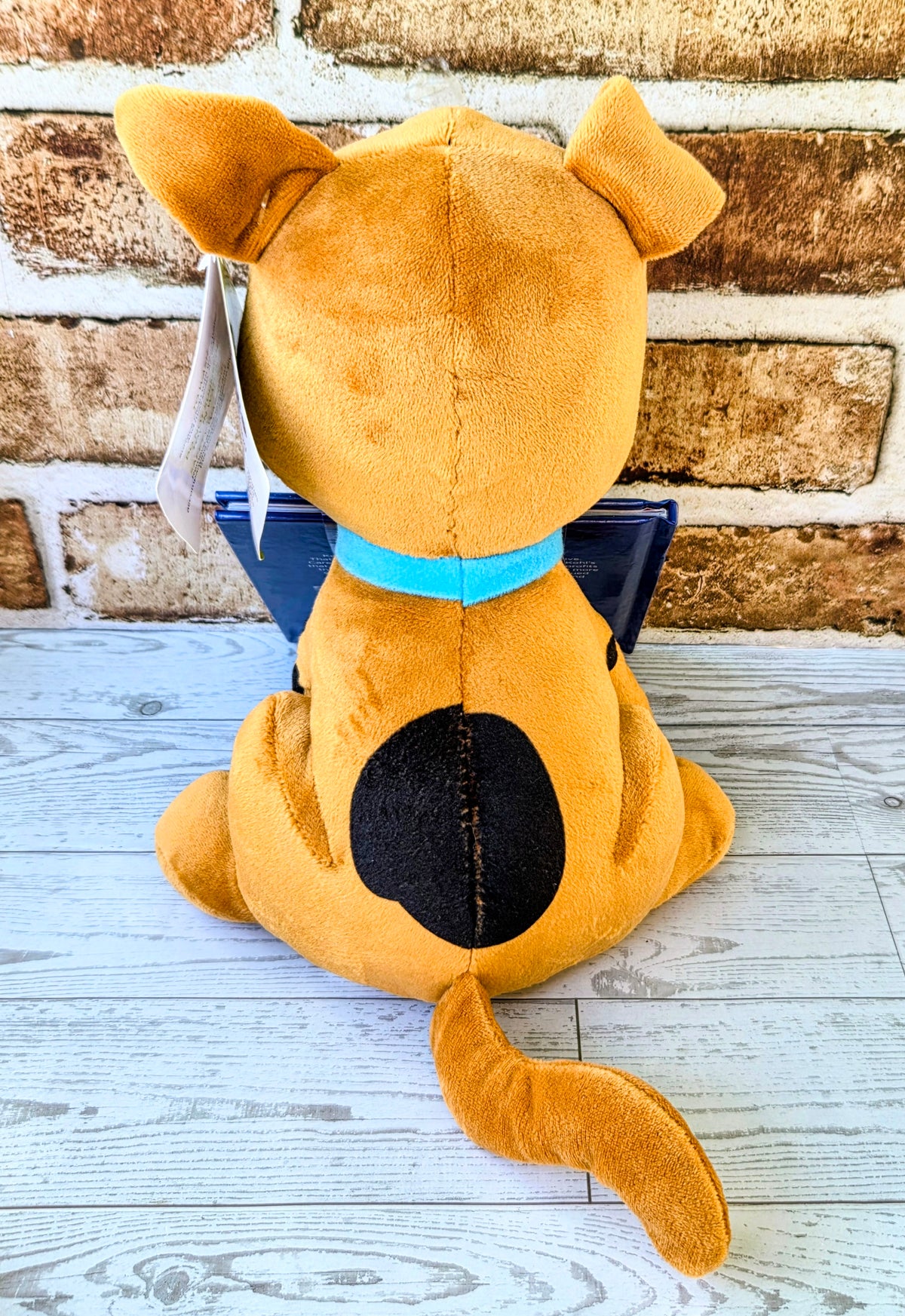 Orange Scooby-Doo plush from behind with a Halloween mystery hardcover book