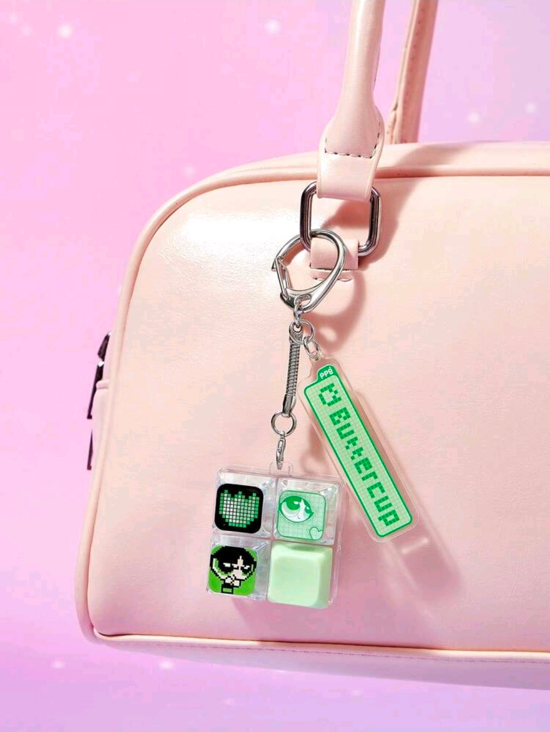 Acrylic fidget keychain with mint screen tiles and green tag, hanging from a bag strap