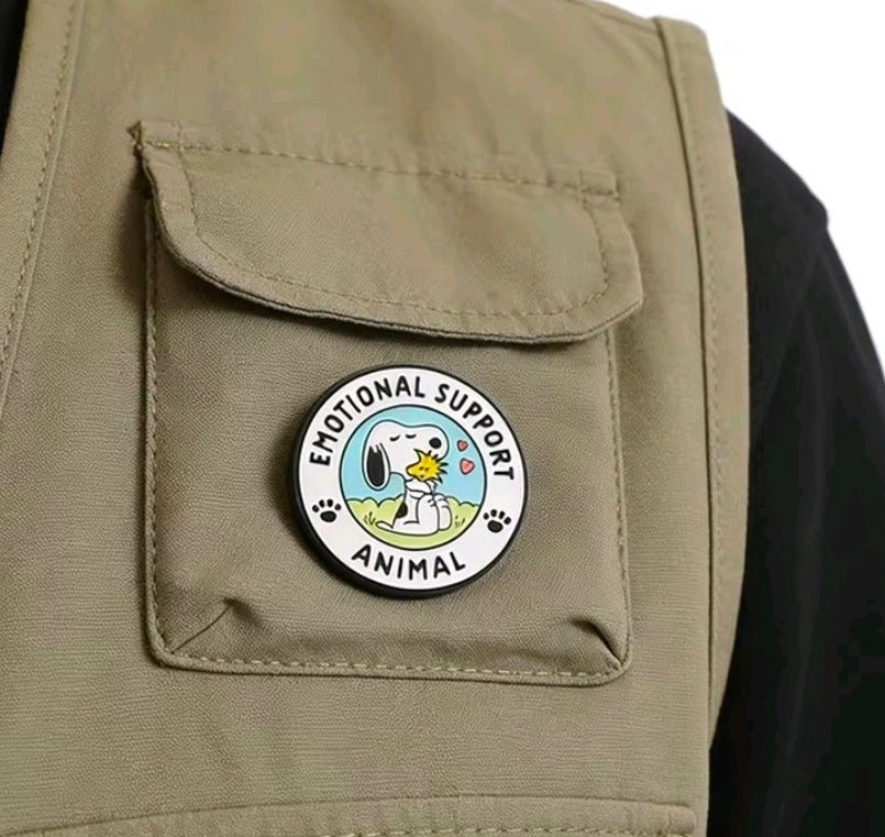 Round Emotional Support Animal enamel pin on tan jacket pocket