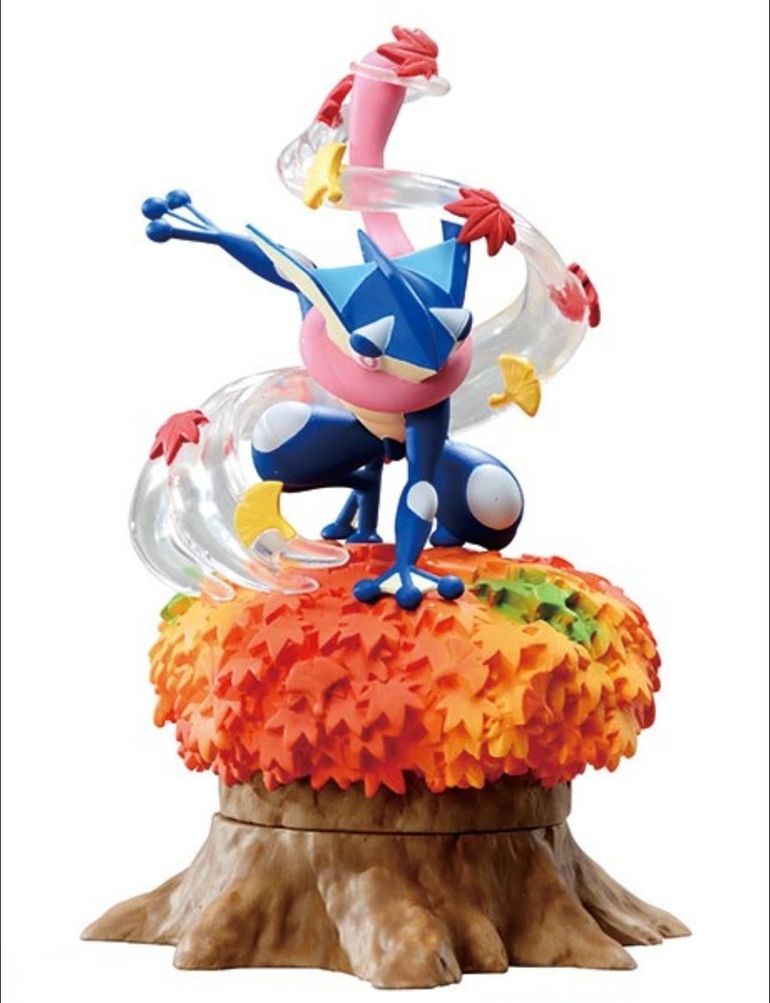 Blue and red lizard-like figure on a round orange leafy tree-stump base