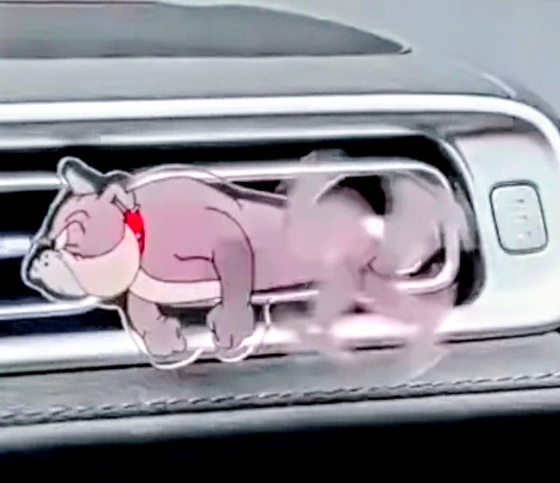 Transparent spinning acrylic mouse clip with pink character on car vent.
