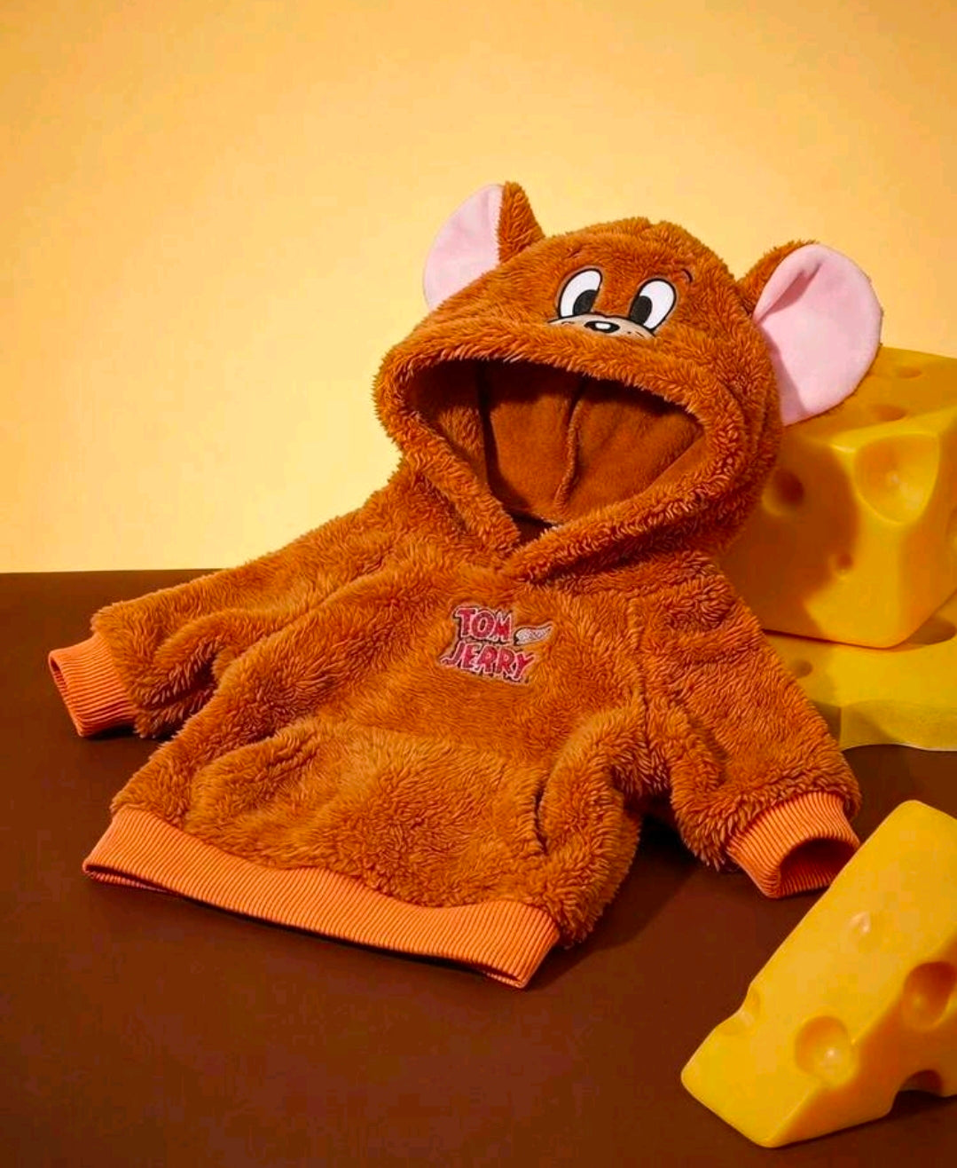 Orange-brown mouse plush dog hoodie with cartoon face and ribbed cuffs, laid flat