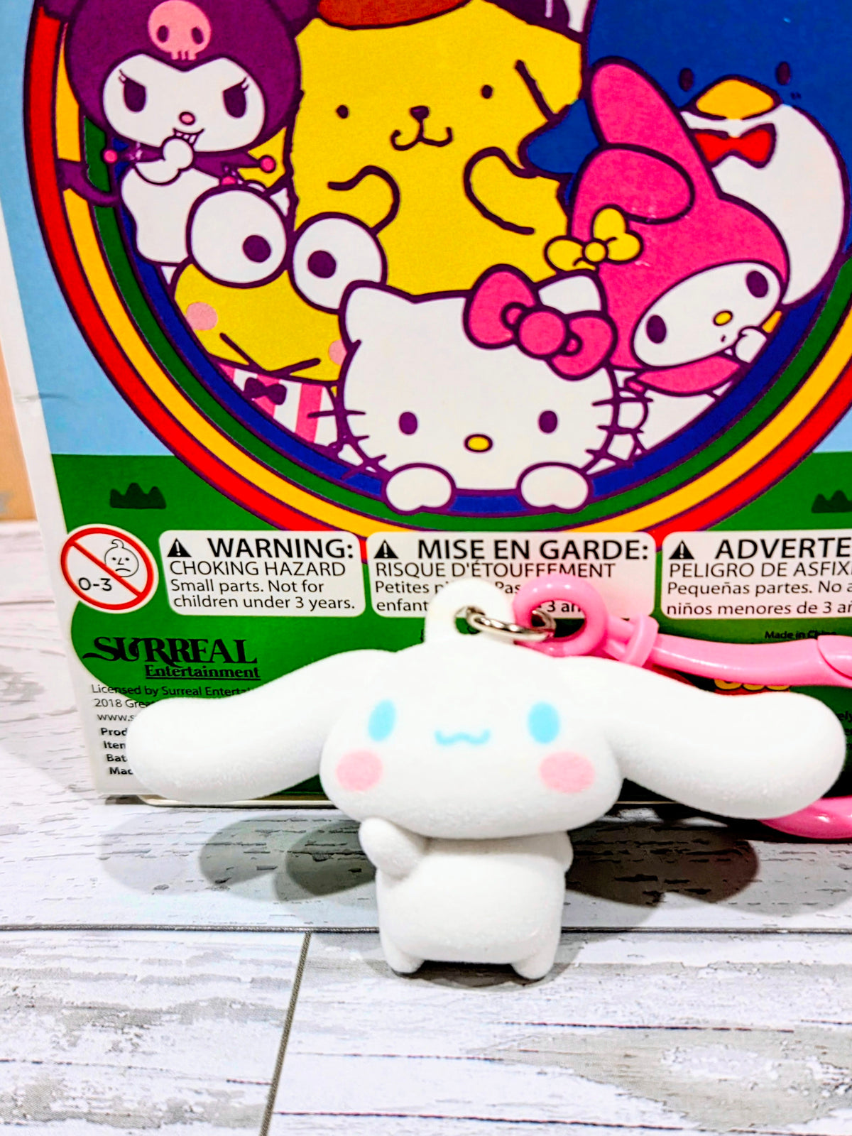 White flocked character keychain with pink ring, front view on colorful box artwork.