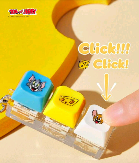 Keychain clicker fidget with blue, yellow, and white blocks pressed by finger