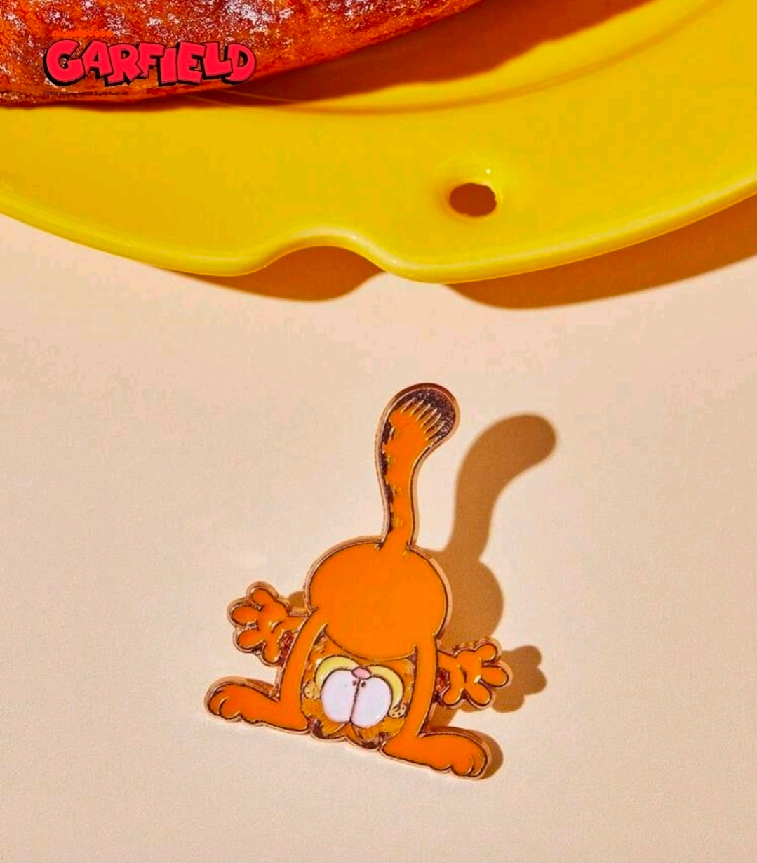 Enamel character pin of an orange cat with a white eye patch, gold-outlined