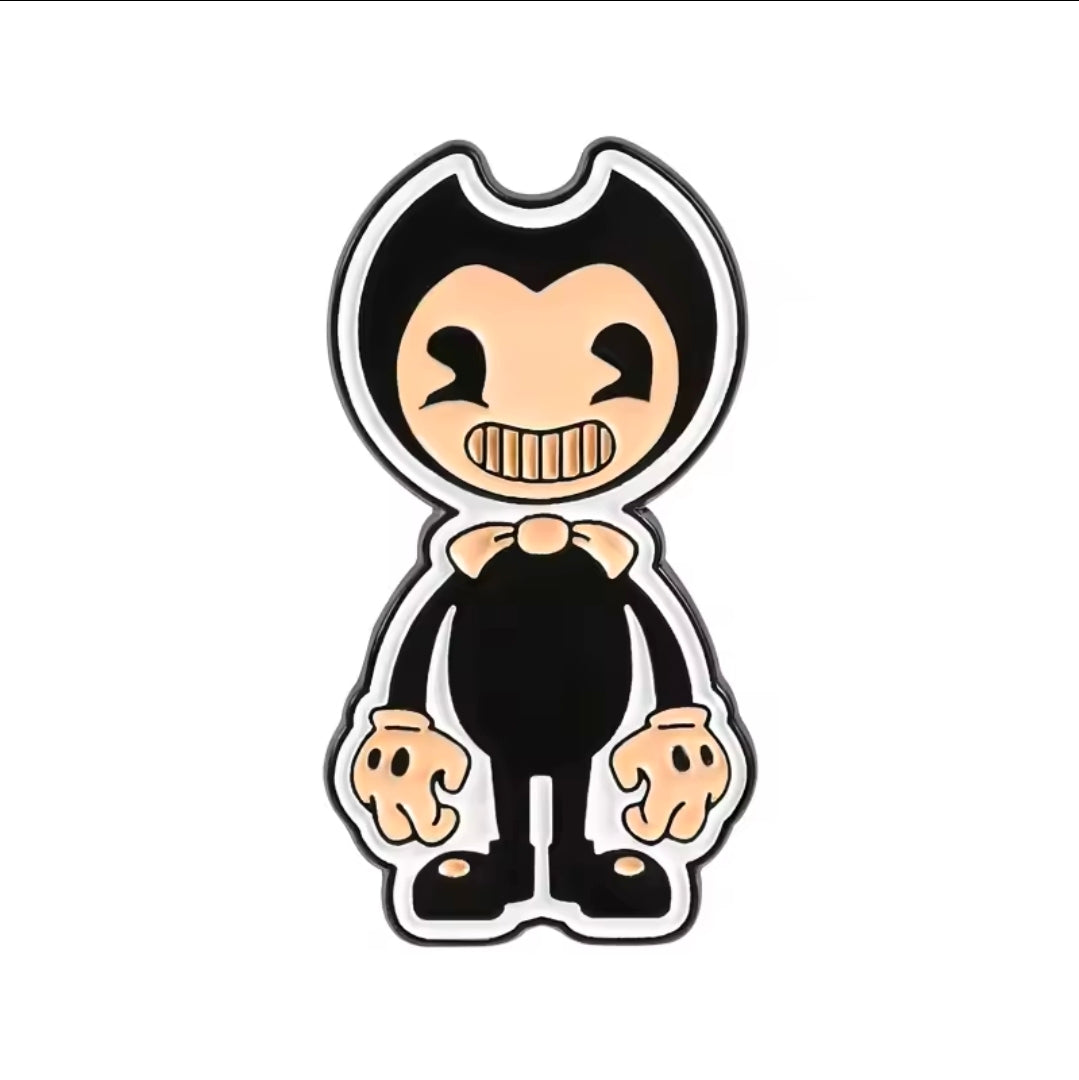 Enamel pin showing a black hooded character with a cream face and a toothy grin