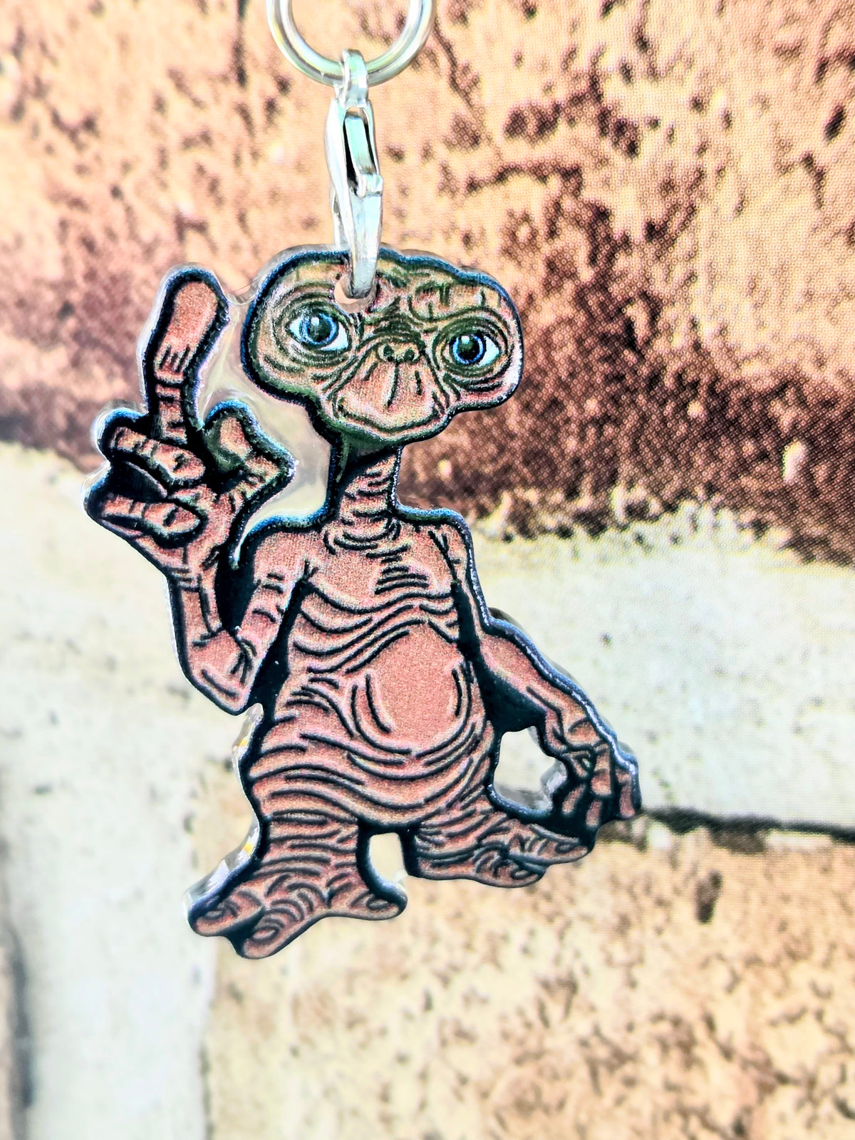 Acrylic E.T. die-cut keychain with gold ring, blue-eyed alien holding finger up