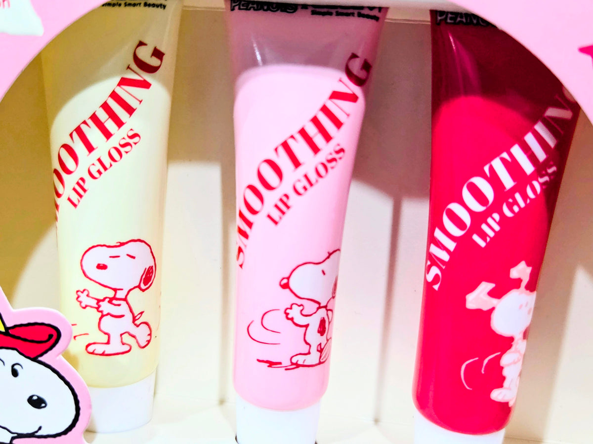 Three Snoopy smoothing lip gloss tubes in cream, pink, and red shades