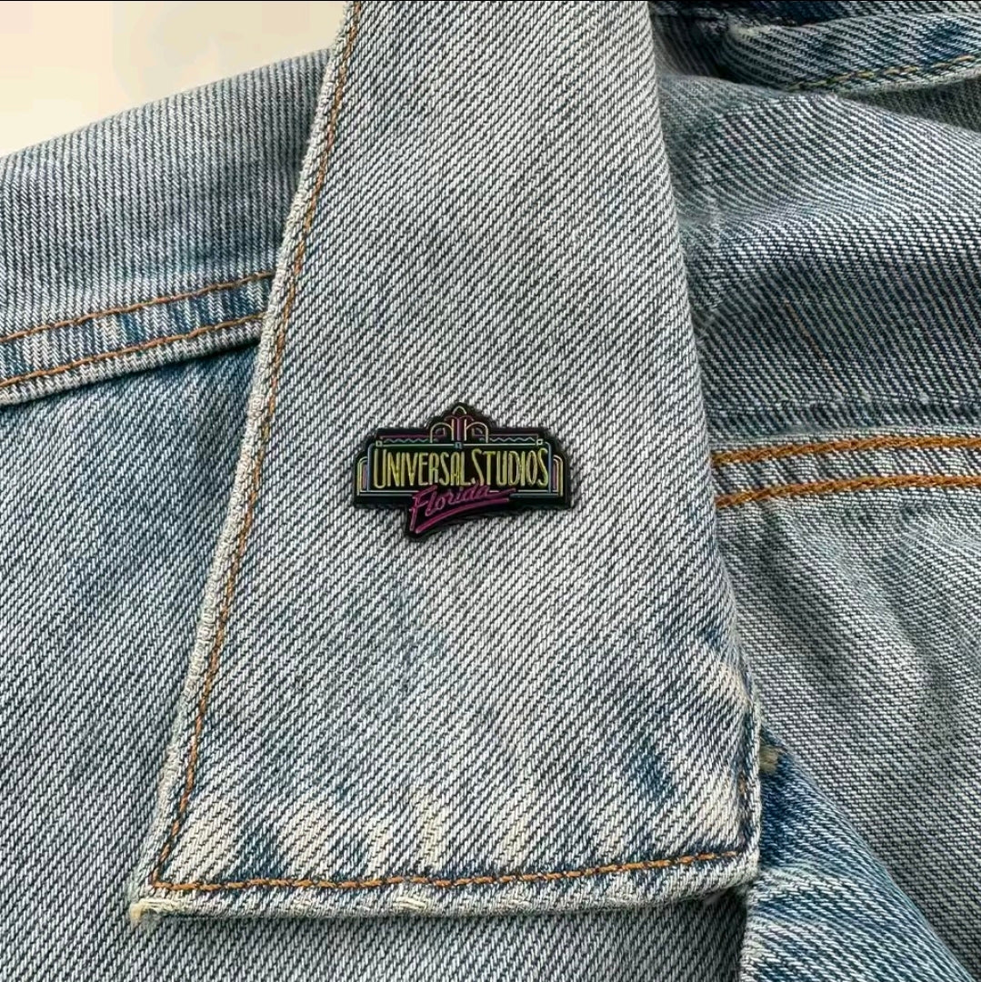 Universal Studios Florida enamel pin on light-wash denim jacket