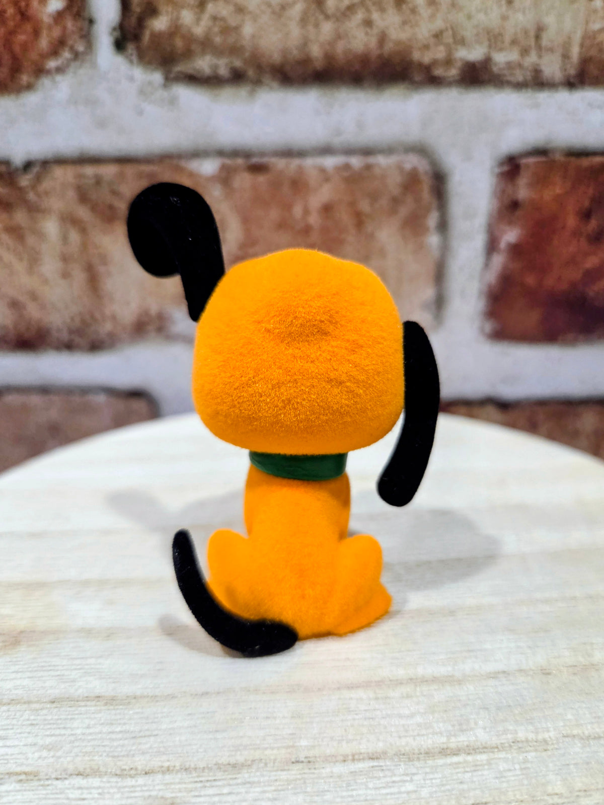 Flocked Pluto mini figure standing, orange plush with black tail and green collar