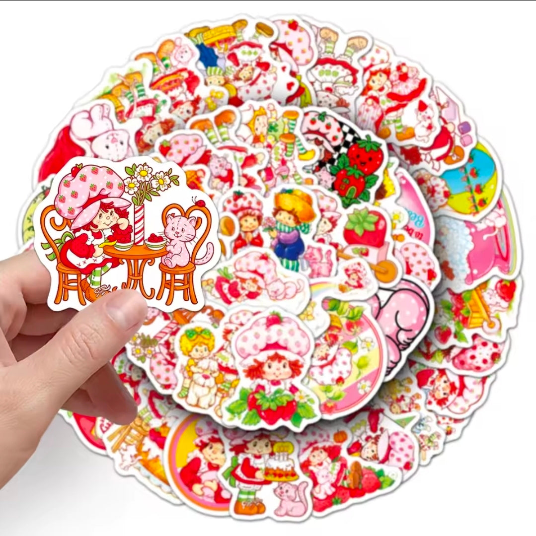 Vinyl die-cut sticker pack with Strawberry-themed cartoon characters, held in hand