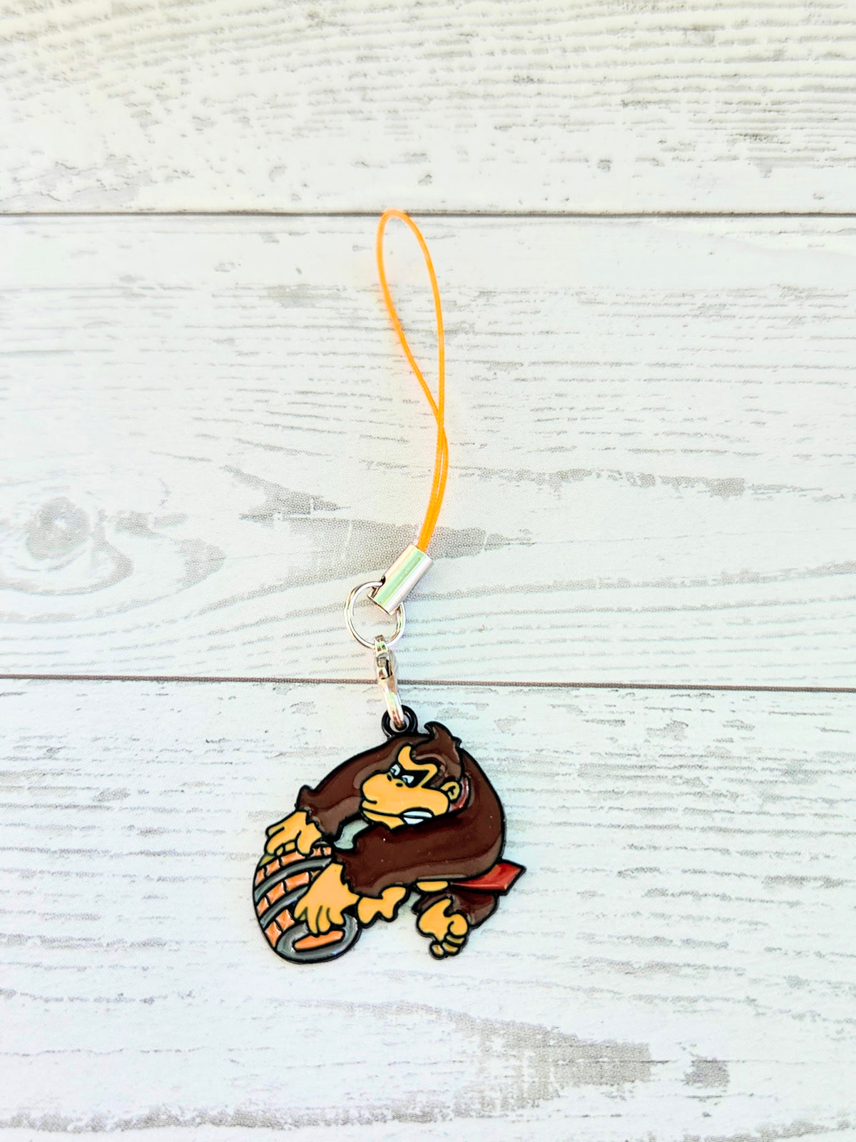 Orange cord phone charm wrist strap with Donkey Kong crouching enamel charm