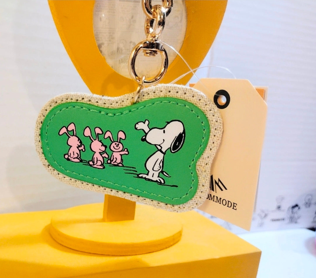 Green Snoopy bunnies keychain on beige fabric, gold split ring clasp