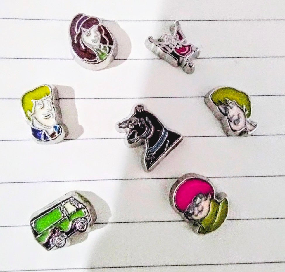 Set of character floating charms on a white striped surface
