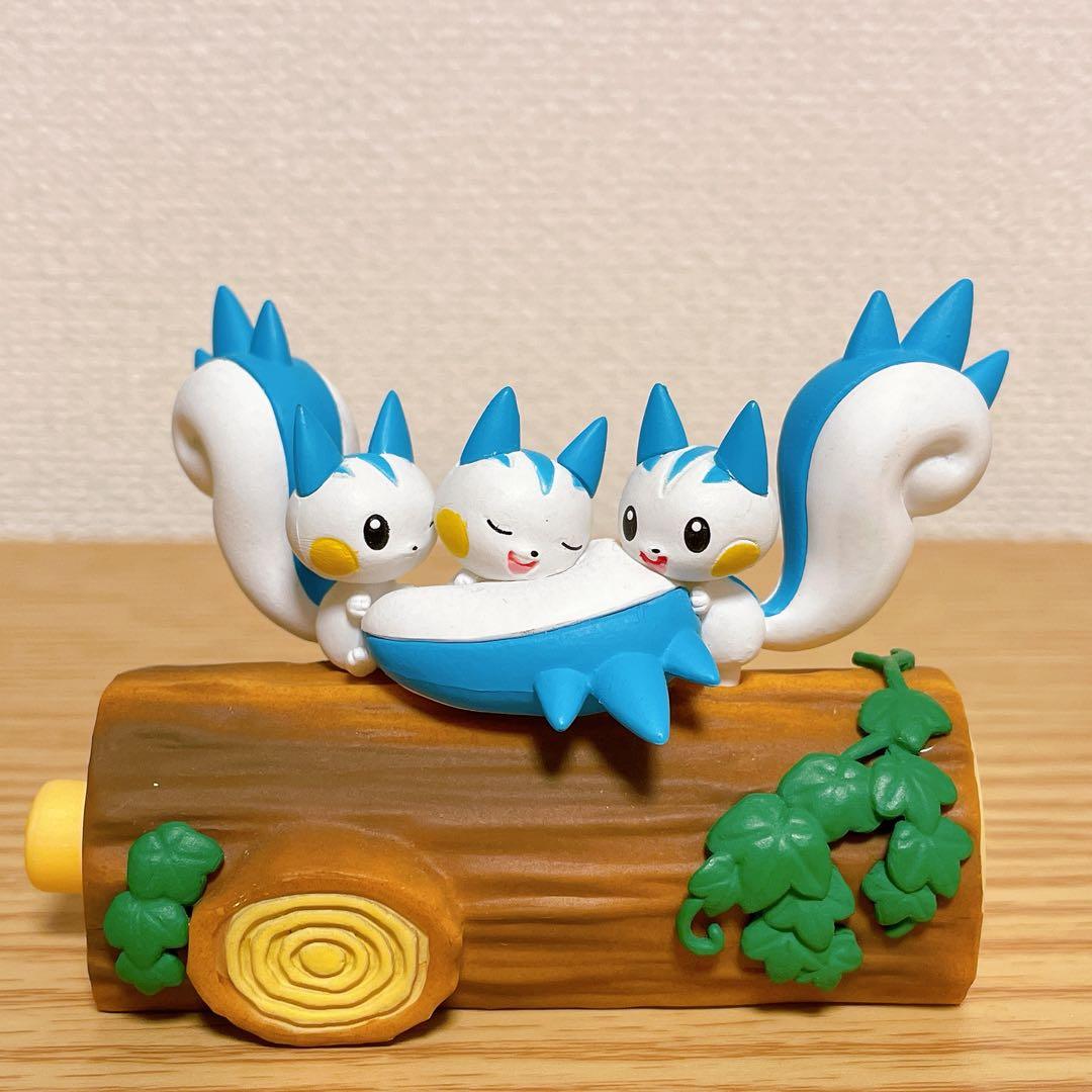 Blue bird-themed toy figures perched together on a brown log with green leaves.