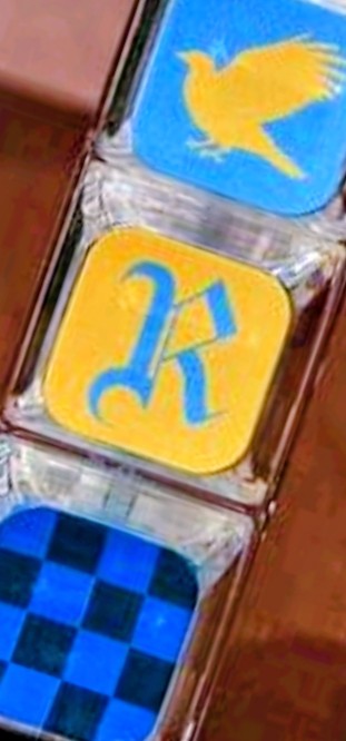 Blue and yellow Ravenclaw fidget keychain charm with bird icon and checkered block