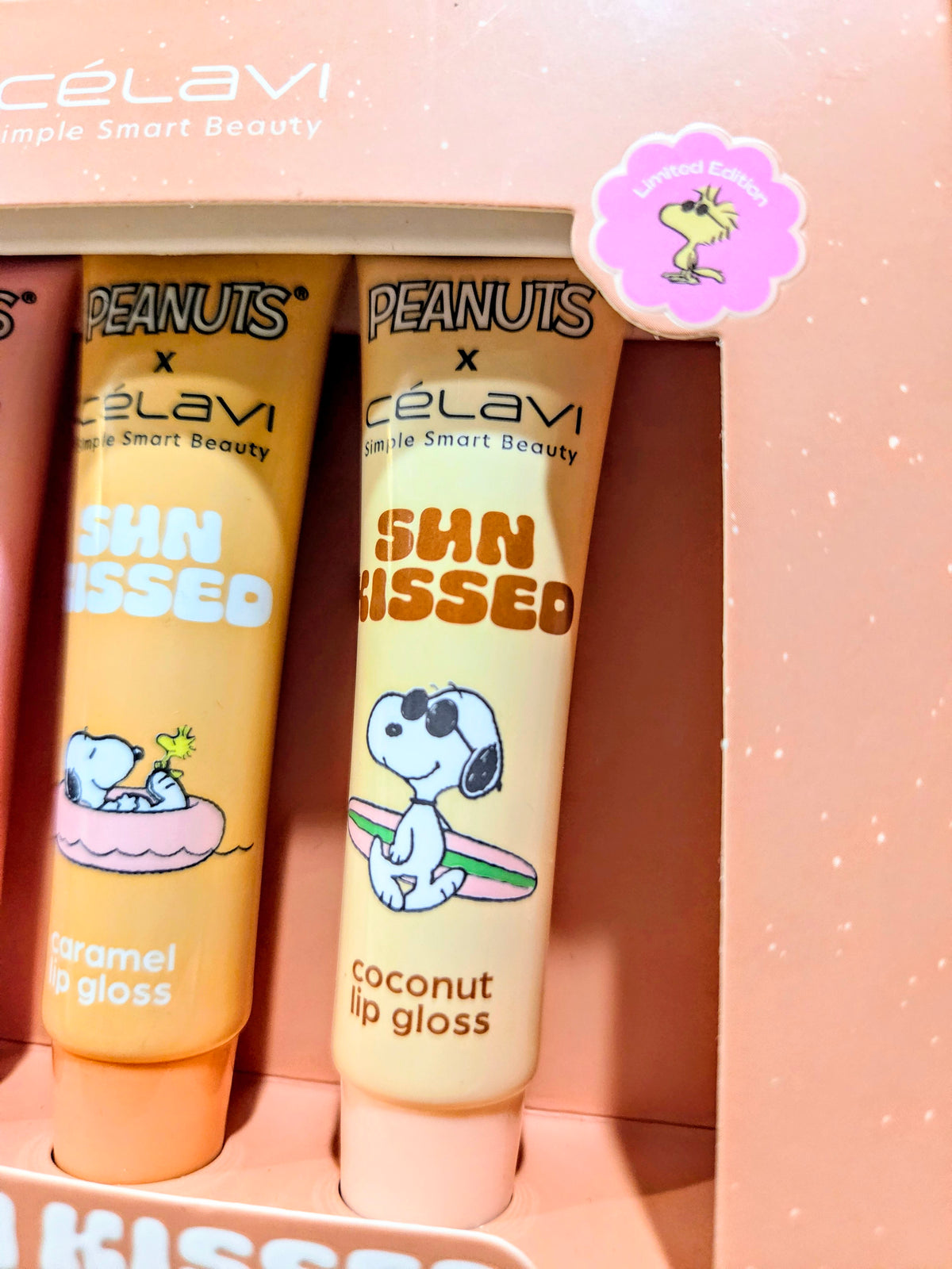 Peanuts Sun Kissed lip gloss tubes with vanilla, strawberry, coconut, and caramel colors