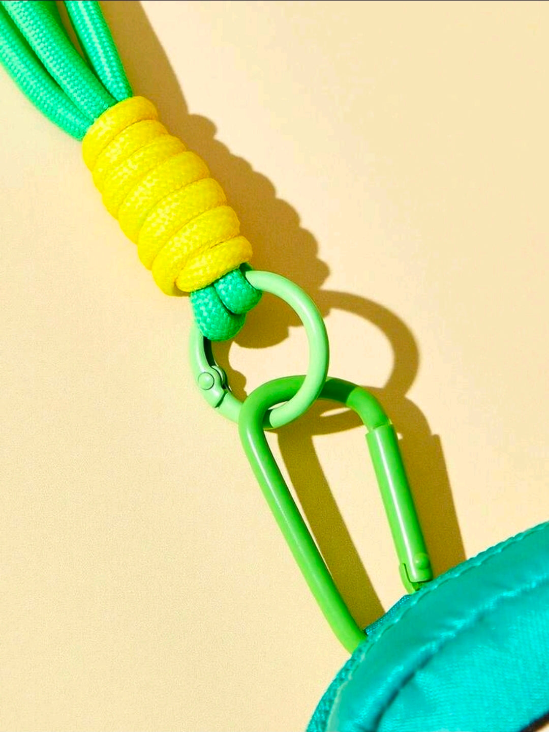 Teal mini pouch strap detail with green carabiner and yellow cord loop