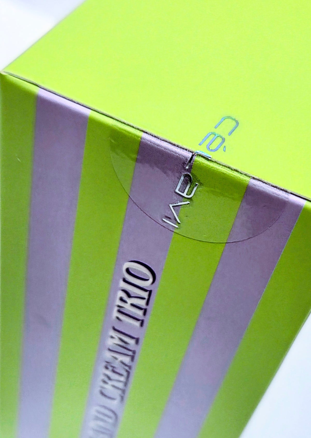 Halloween beauty gift set box top with green, purple stripes and “trio” label window