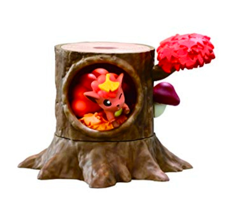 Red creature figure peeking from a hollow tree-stump with autumn leaf decorations