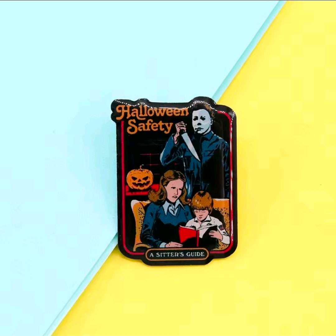 Enamel pin with "Halloween Safety" graphic showing Michael Myers and kids