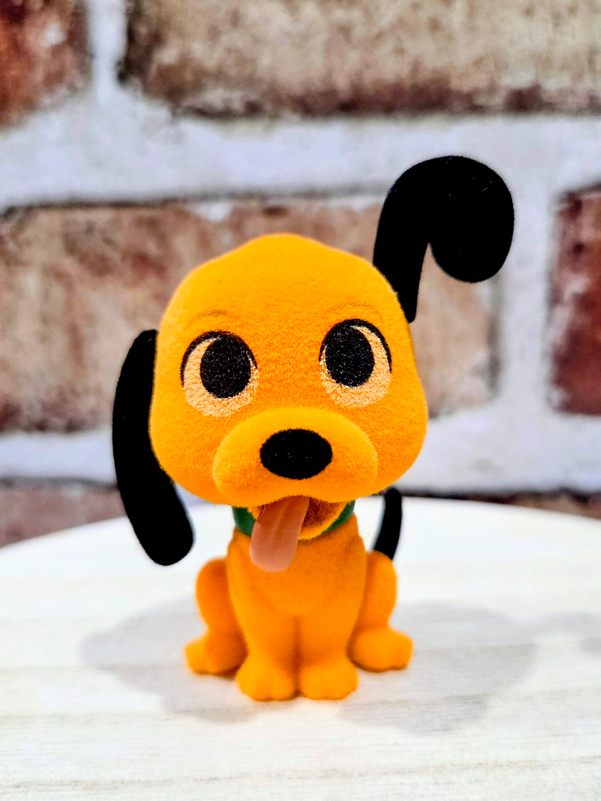 Flocked Pluto mini figure front view, orange plush with big eyes and green collar