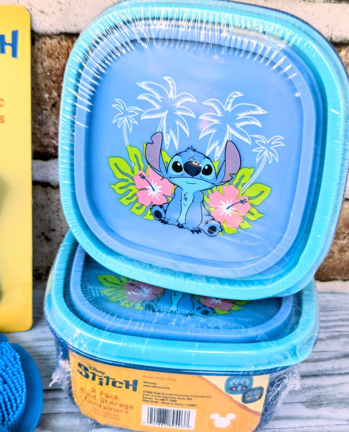 Stacked light-blue Stitch reusable containers with tropical palm design