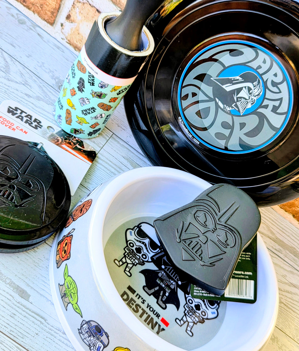 Black pet bowl with blue logo and white pet dish with Vader face