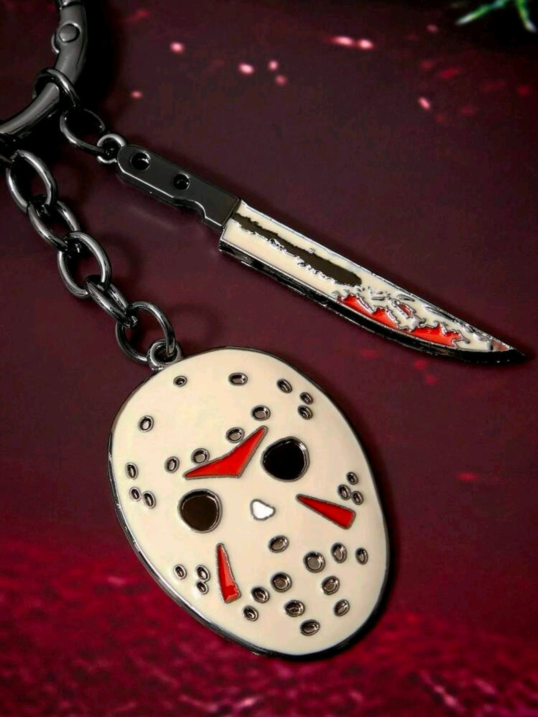 Enamel mask charm keychain with black chain links and silver red-edged dagger charm