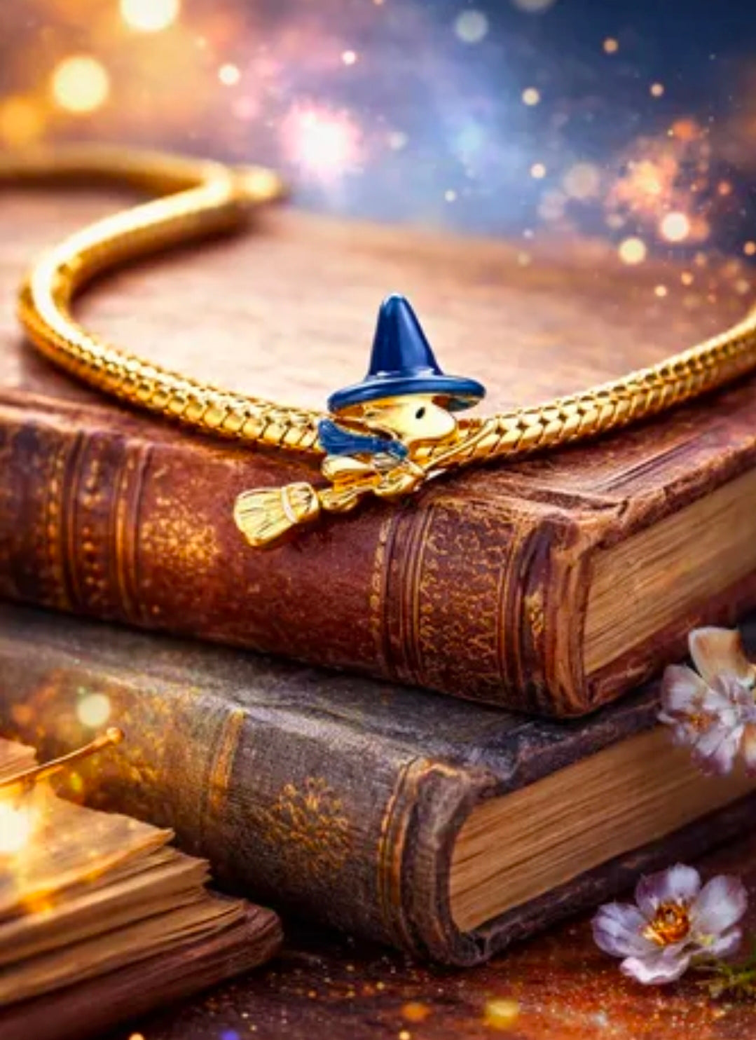 Gold-tone witch charm with blue pointed hat and broom, detailed small figure