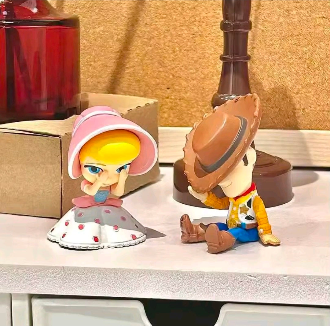 Two Toy Story gashapon figures with character boxes on a display shelf