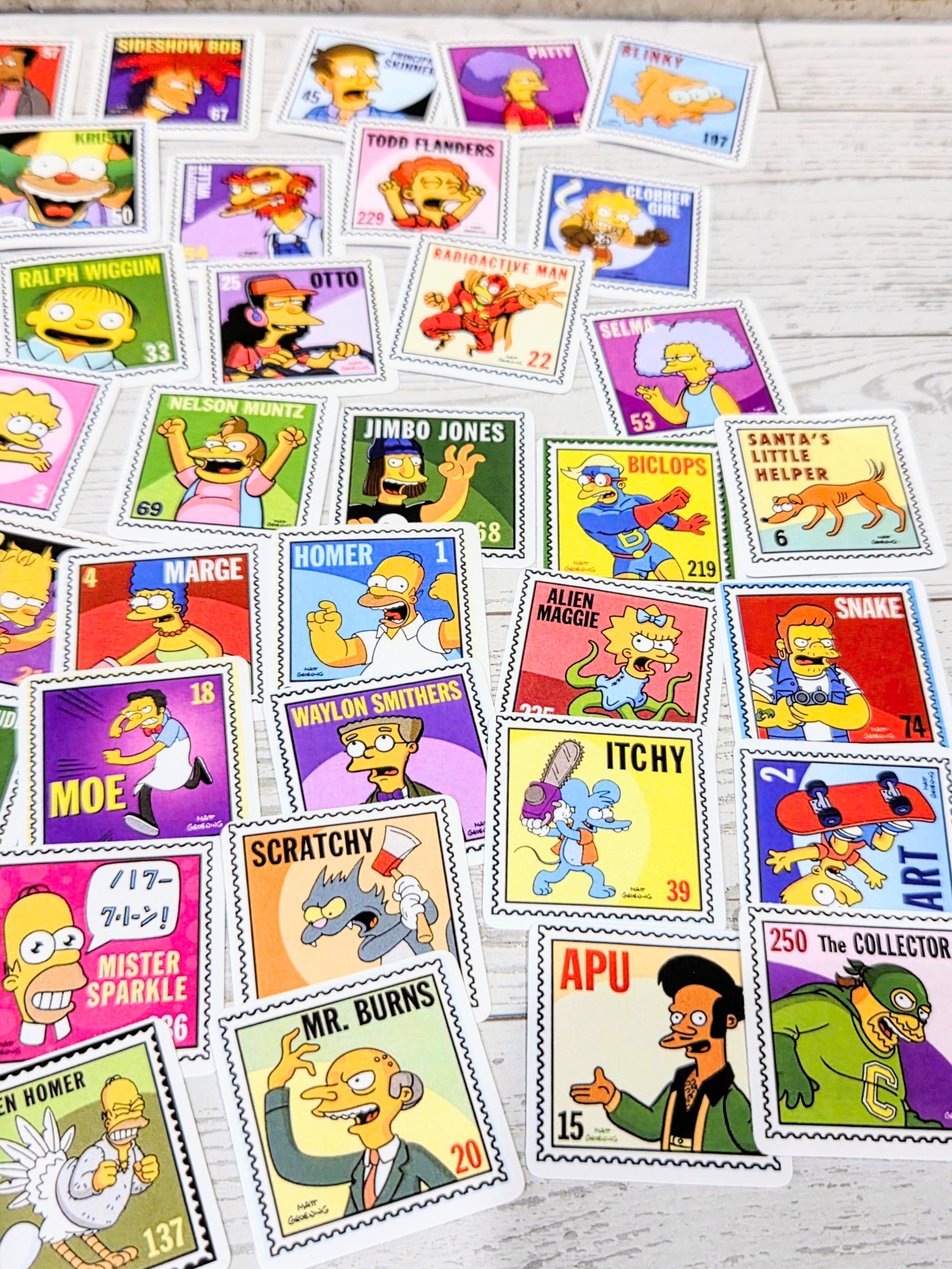Overhead view of Simpsons postage-stamp style stickers featuring multiple characters and character names