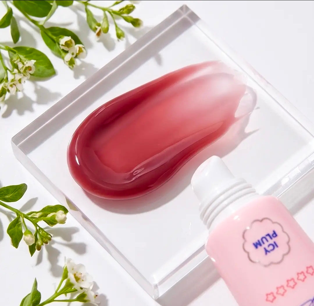 Icy plum lip gloss swatch on clear tray with pink tube and white cap
