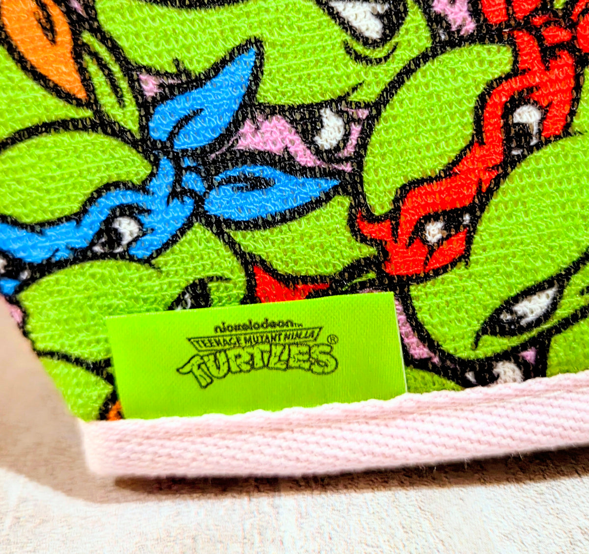 Teenage Mutant Ninja Turtles bath mitt with pink trim and green character fabric