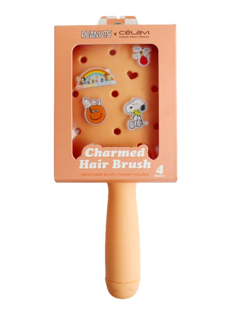 Peach paddle hair brush with cartoon Peanuts charms, front box and handle
