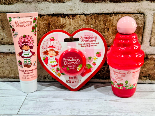 Heart-shaped self-care tin with Strawberry Shortcake label, plus lotion tube and bottle