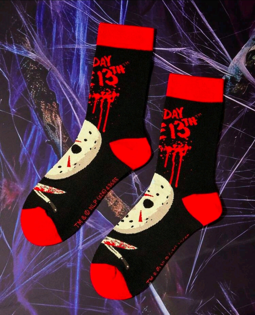 Pair of black crew socks with red cuffs, white hockey-mask faces, and logo print