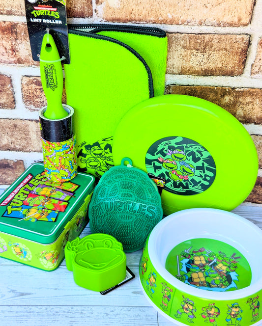 Neon green pet bowl, TMNT frisbee, square lint brush, and lint roller in gift pouch