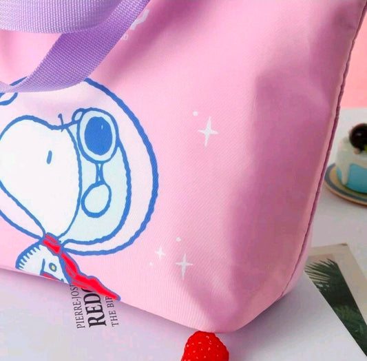 Corner view of pink insulated lunch bag with blue Snoopy print and small star details