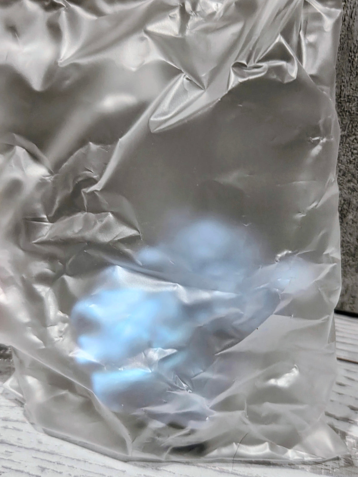 Silver plastic-wrapped item with translucent contents inside