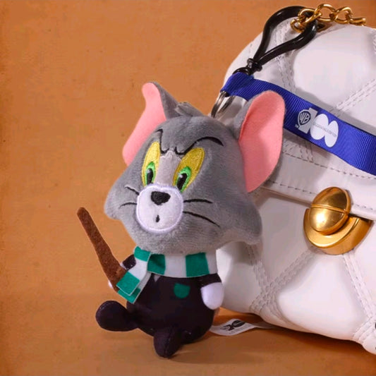 Grey wizard cat plush keychain close-up with blue strap, green eyes, and gold bell charm