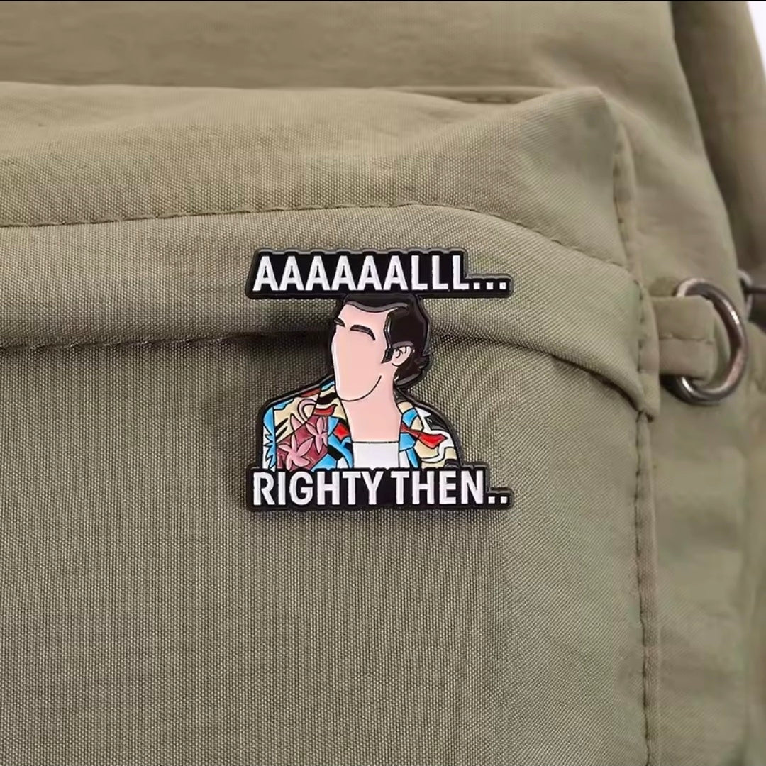 Enamel pin with cartoon man and text “AAAAAAALL… RIGHTY THEN..” on tan jacket