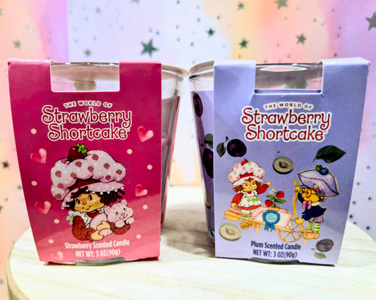 Candle gift set with two illustrated boxes: strawberry-pink and plum-purple scented candles
