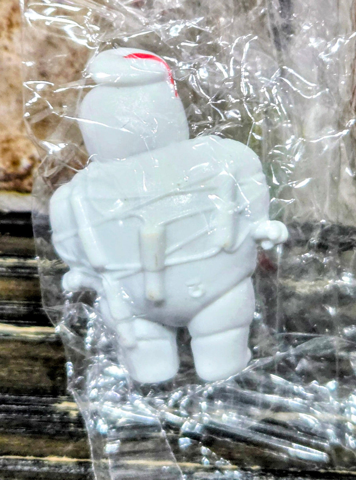 White Mini-Puft ghost figure holding a gray canister, in clear plastic bag