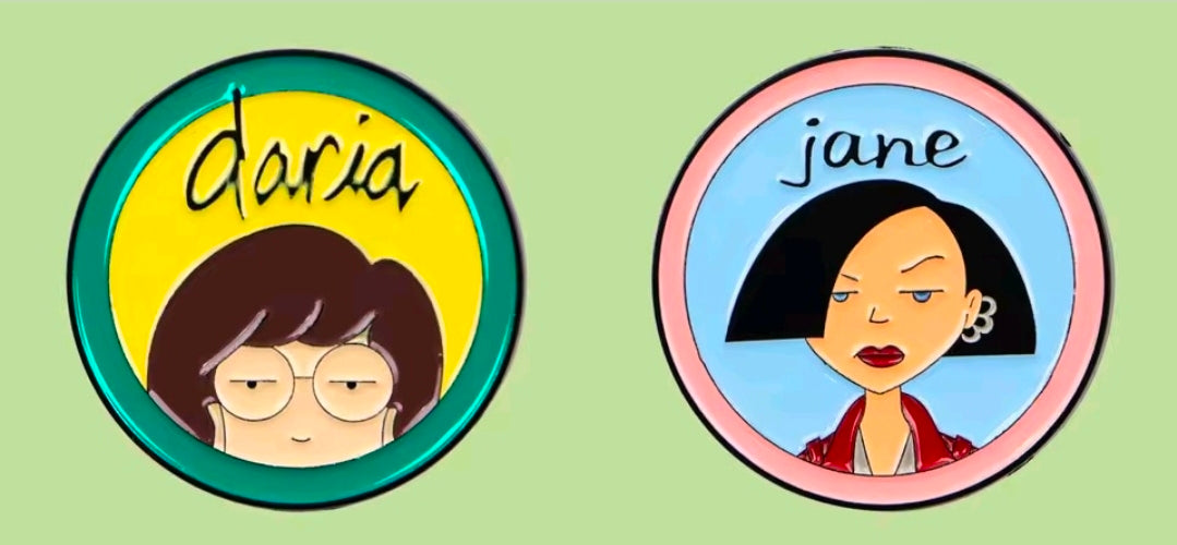 Two circle character enamel pins: Daria and Jane