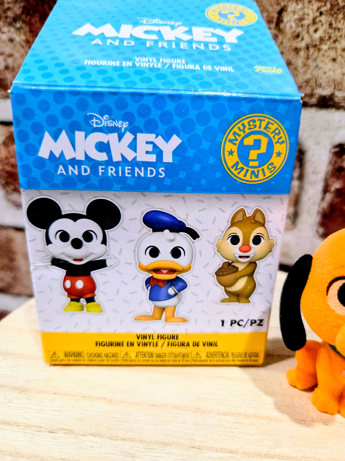 Disney Mickey and Friends mystery mini box beside flocked Pluto figure