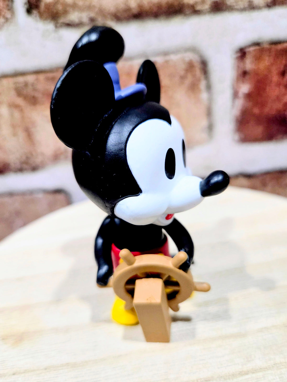 Mickey Mouse mini vinyl figure holding a tan box-like prop, side view