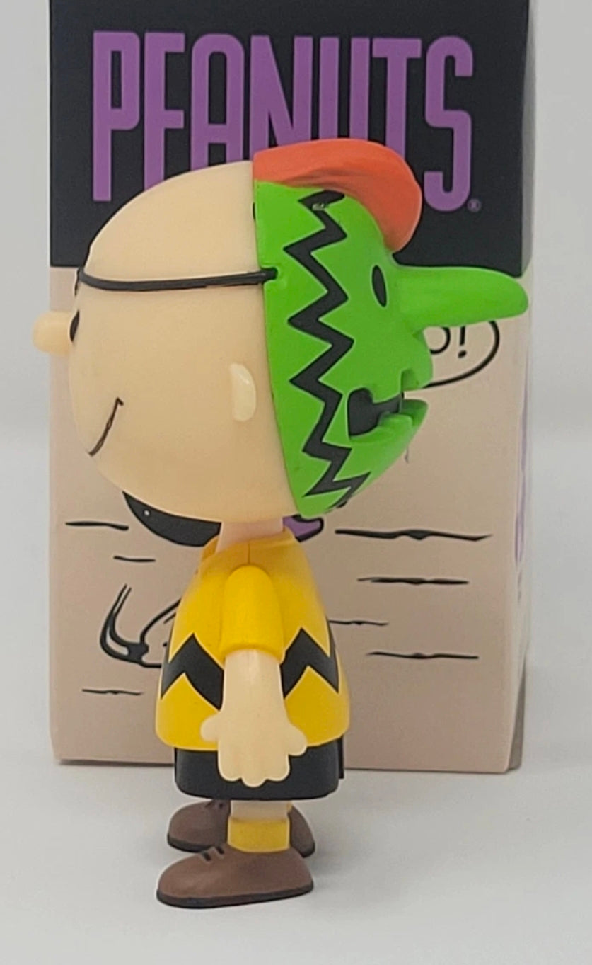 Green-masked dog Halloween figure with black eye area and yellow outfit, beside tan box